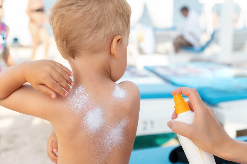 Sun cream being applied to a child's back and shoulders