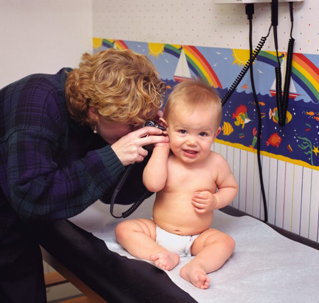 Adult gently examining a young child's ear