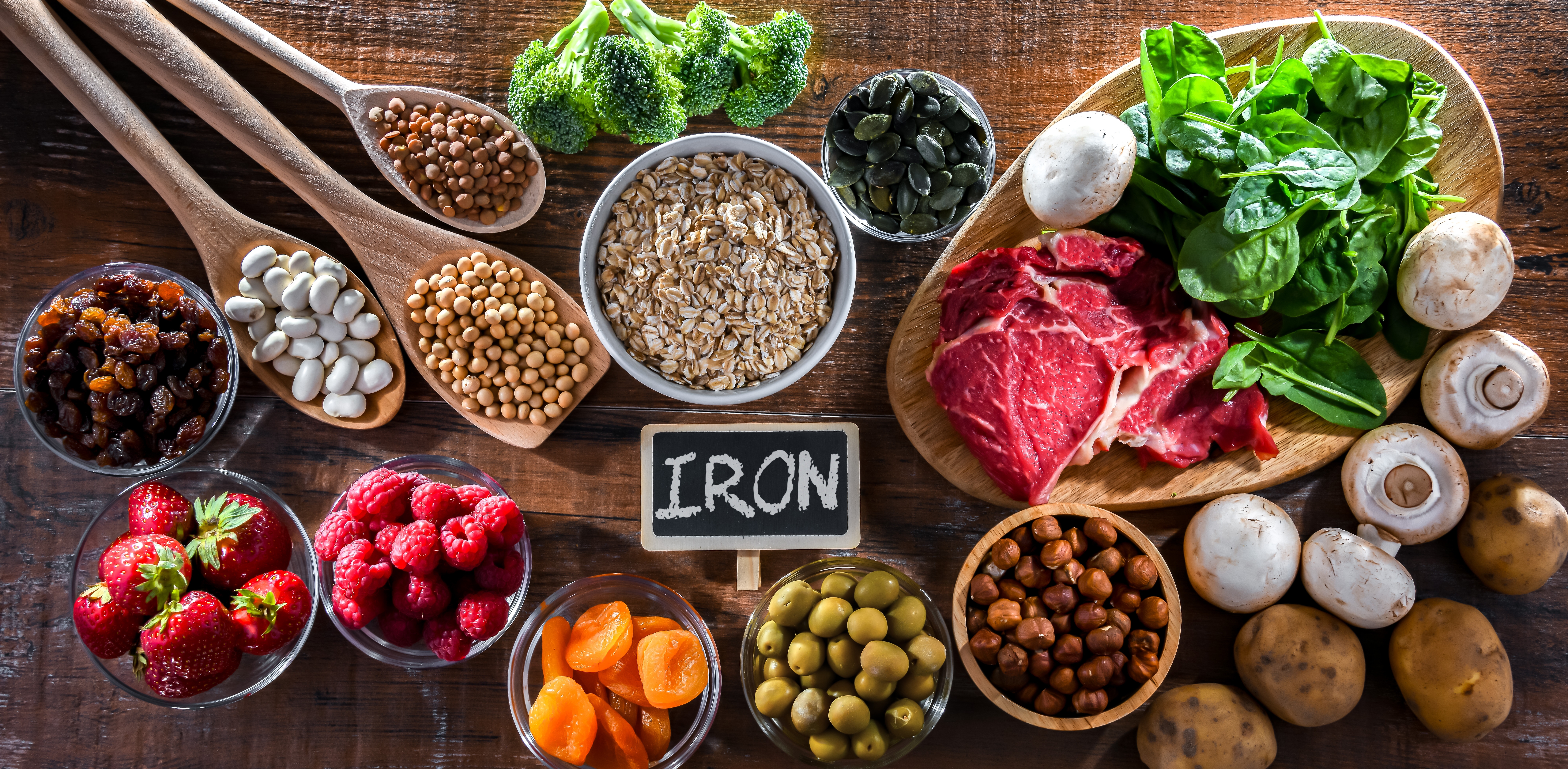 Iron-rich foods including red meat, leafy greens, beans, seeds and berries