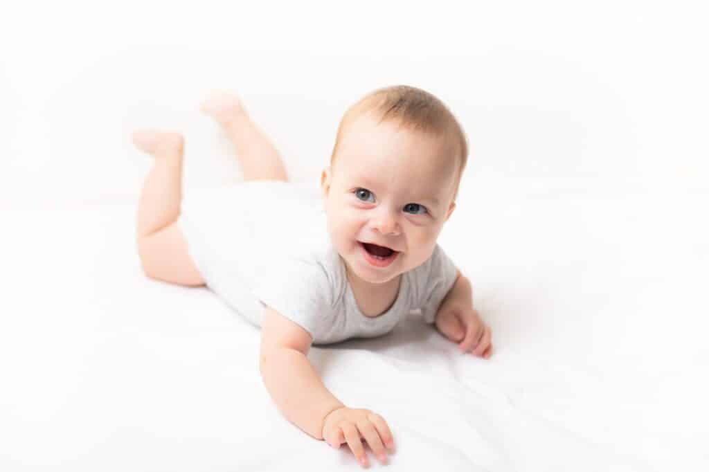 Smiling baby propped up on their arms during tummy time